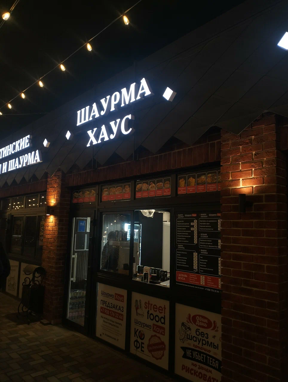 Фасад Шаурма Хаус вечером с подсвеченной вывеской и гирляндой